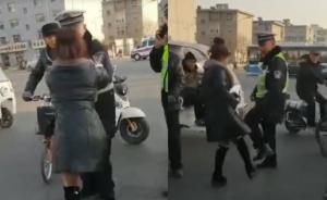 女子骑电动车闯红灯被查,居然踢踹民警
