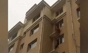 消防员从天降，一脚将跳楼女子蹬回屋