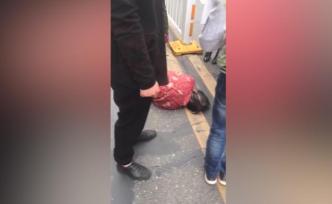 老人晕倒路中，快递员与路人围成人墙保护