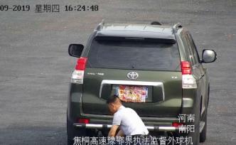 過(guò)收費(fèi)站前，豐田霸道車主用年畫擋車牌