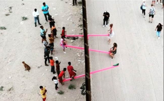 美墨邊境粉色蹺蹺板，兩國(guó)兒童隔墻玩耍