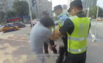 橫穿馬路被勸，女子躺地撒潑辱罵咬民警