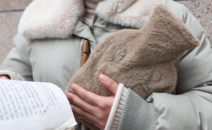 考研女生室外抱熱水袋背書，滿手凍瘡