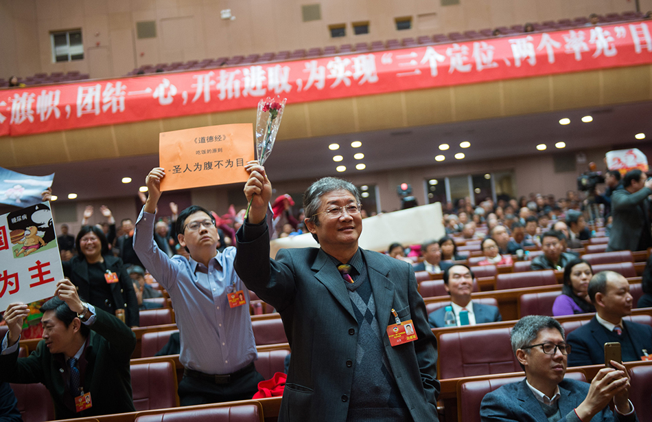 6.一位委員將紅色圍巾圍在頭上。