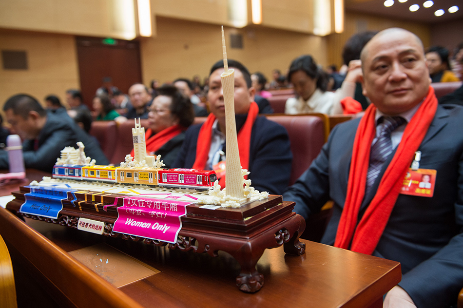 湯鎮(zhèn)業(yè)委員面前有一副廣州地鐵工藝品。