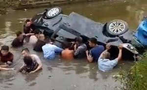 轿车被撞翻入河道，众村民跳水砸车救人