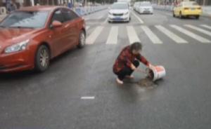 7旬老人自带水泥铲子，车流中填补路坑