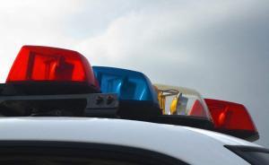 四川两男子踩警车拍照，其中一人因未成年被教育免予处罚