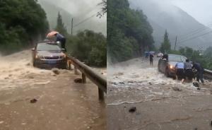 突发山洪车被困路旁，交警冒险踩护栏救