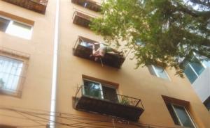 沈陽一男子跳樓懸掛四樓花臺，民警緊抓住其手腳直到等來救援