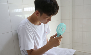 三伏天室外背誦戰(zhàn)考研，大學(xué)生棄空調(diào)房手持小風(fēng)扇降溫